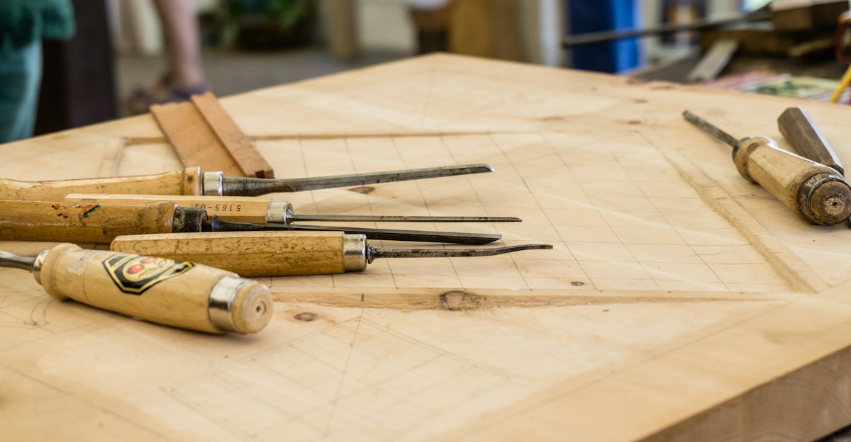 A row of wooden-handled chisels on a workbench