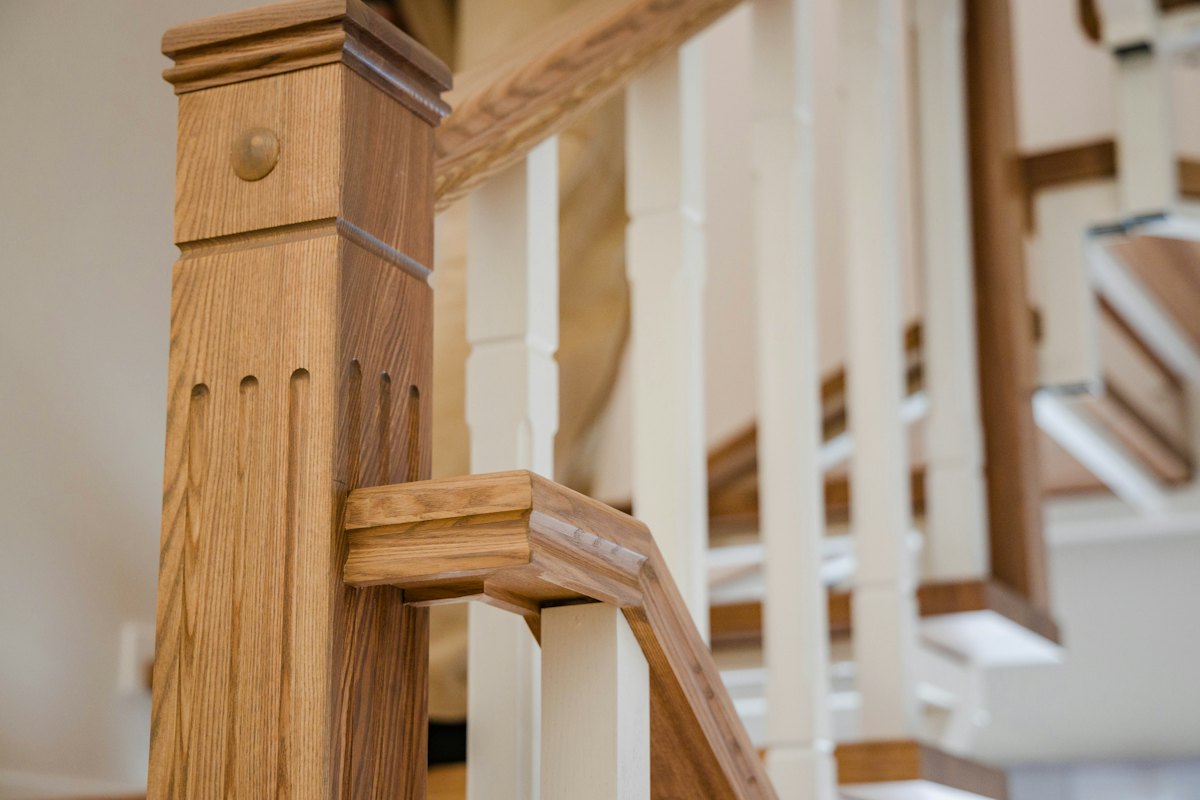 Close-up of an oak newel post and white balustrade