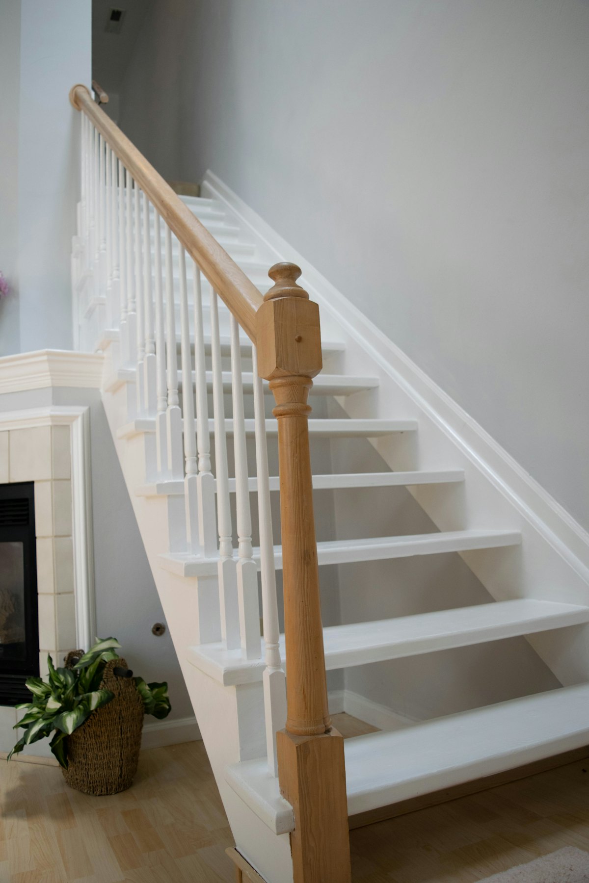 A white painted staircase with an oak newel post and handrail